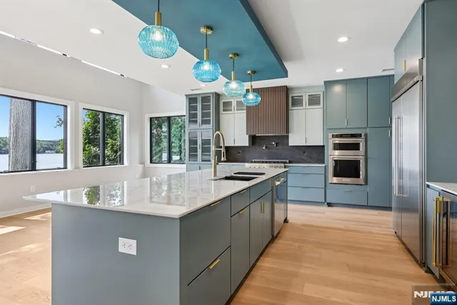 a kitchen with stainless steel appliances granite countertop a sink a stove and a refrigerator