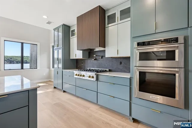 a kitchen with stainless steel appliances granite countertop a stove microwave and cabinets
