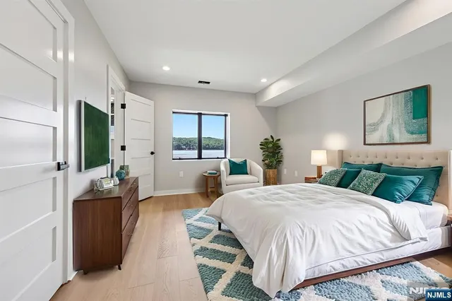 a spacious bedroom with a large bed and a flat screen tv