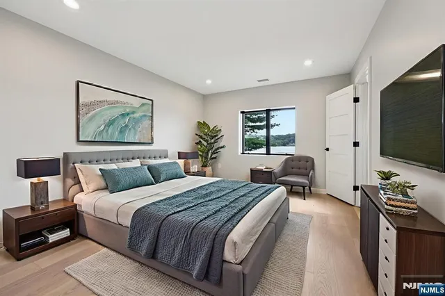 a spacious bedroom with a large bed and a flat screen tv