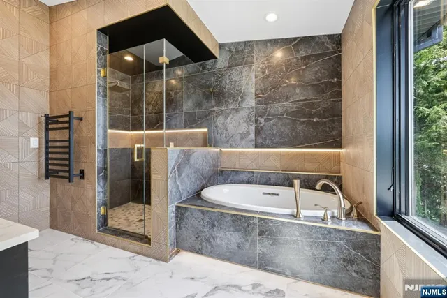 a bathroom with a granite countertop tub shower and sink