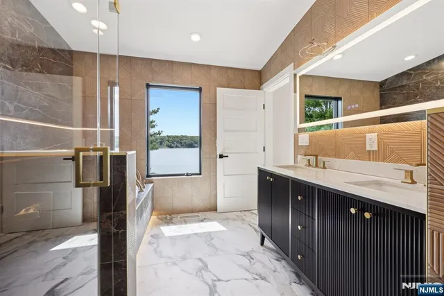 a bathroom with a granite countertop sink a mirror and shower