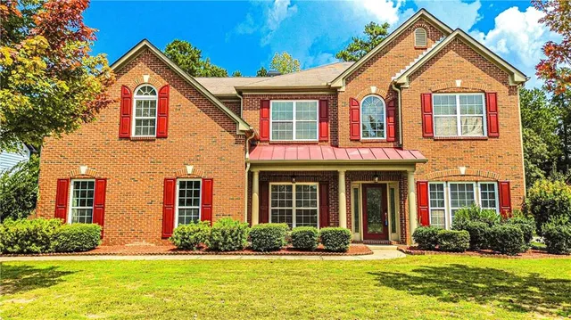 a front view of a house with garden and porch