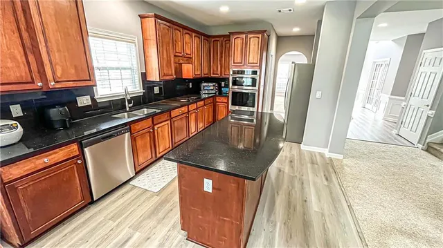 a view of a hallway with wooden floor and entryway