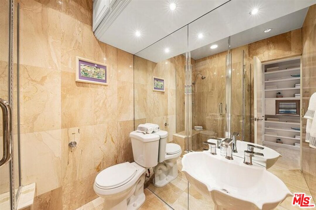 2345 Roscomare Road, Unit 201 Los Angeles, CA 90077 - Photo 13 of 18 a bathroom with a granite countertop sink a toilet a mirror and shower