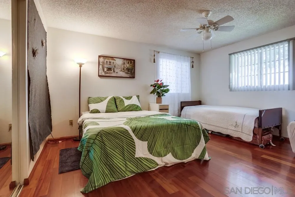 569 E Street, Unit 27 Chula Vista, CA 91910 - Photo 14 of 20 a spacious bedroom with a bed a window and a chandelier