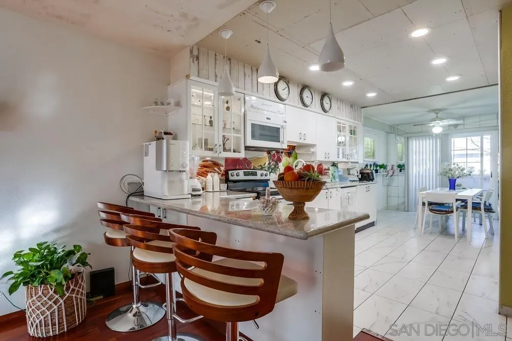 569 E Street, Unit 27 Chula Vista, CA 91910 - Photo 5 of 20 a room with stainless steel appliances kitchen island granite countertop a table chairs and a refrigerator
