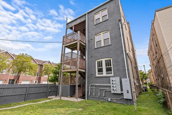 a view of a house with backyard and iron fence