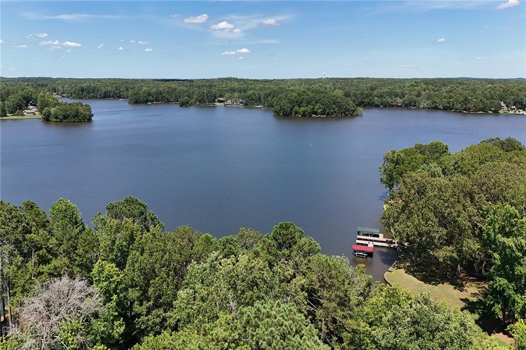an aerial view of a houses with a yard and lake view