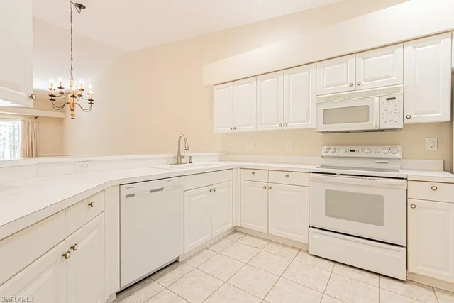 a kitchen with white cabinets and white appliances