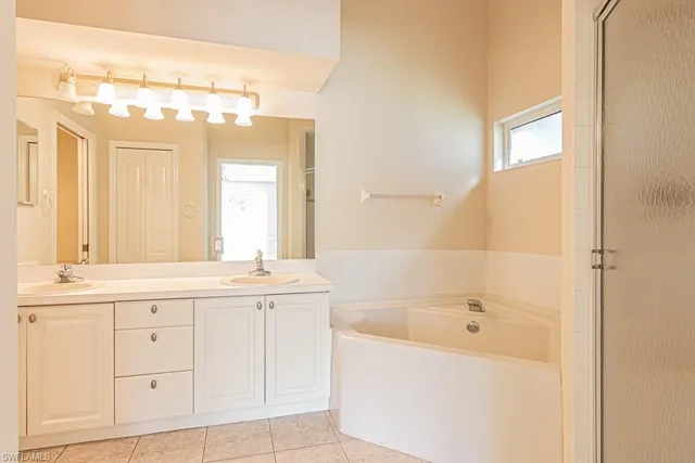 a bathroom with a tub sink and mirror