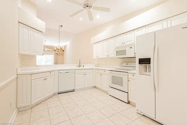 a kitchen with white cabinets and white appliances