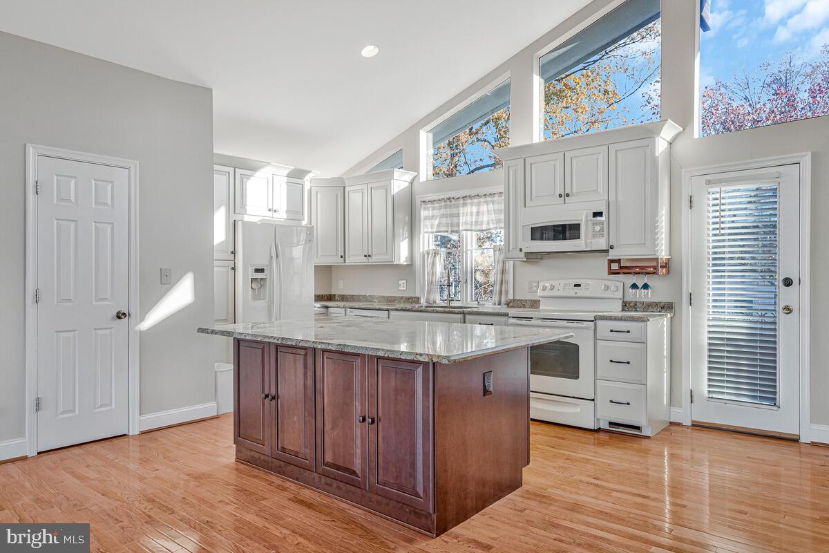 962 Main Street Deale, MD 20751 - Photo 15 of 54 a kitchen with stainless steel appliances granite countertop a stove a sink dishwasher and a refrigerator with wooden floor