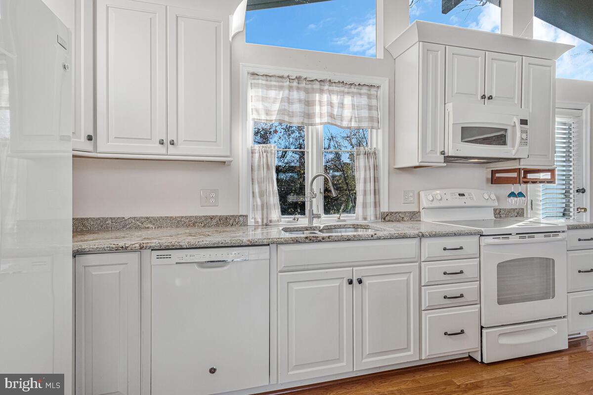 962 Main Street Deale, MD 20751 - Photo 18 of 54 a kitchen with granite countertop white cabinets and white appliances