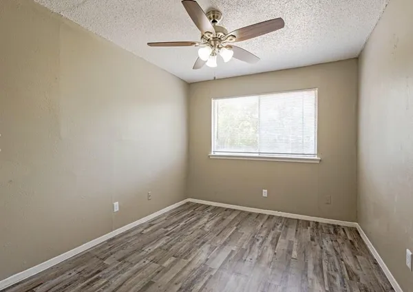 an empty room with a window and wooden floor
