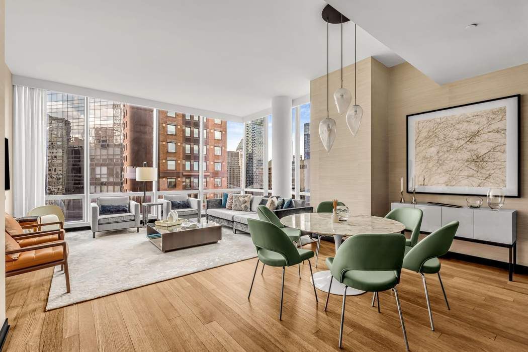 a living room with furniture and floor to ceiling windows