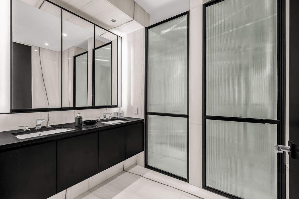 157 West 57th Street, Unit 35E Manhattan, NY 10019 - Photo 5 of 12 a bathroom with a double vanity sink and mirror