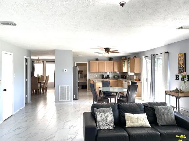 a living room with furniture and view of kitchen