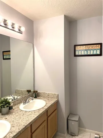 a bathroom with a granite countertop sink a toilet and a mirror