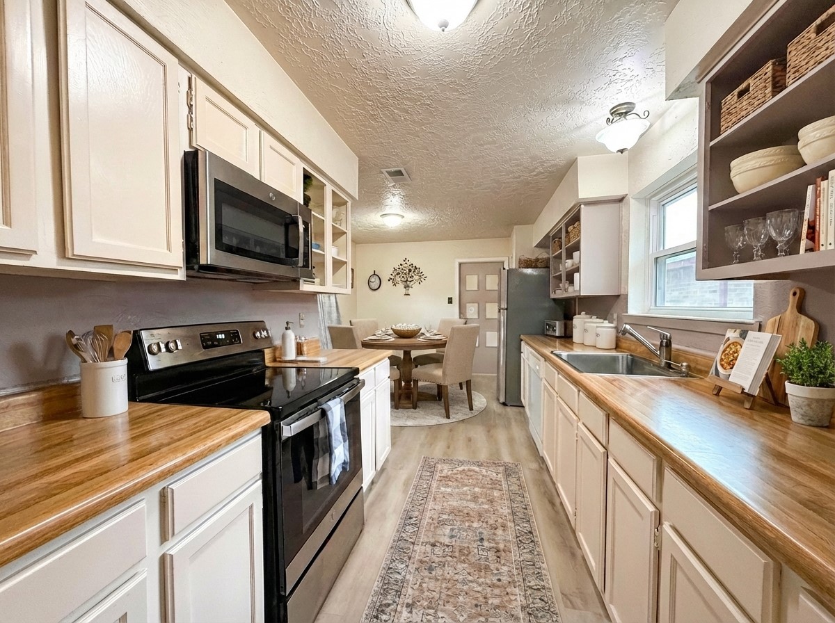 4831 Diehlwood Place Spring, TX 77388 - Photo 6 of 12 a kitchen with stainless steel appliances a stove top oven a sink a counter space and cabinets