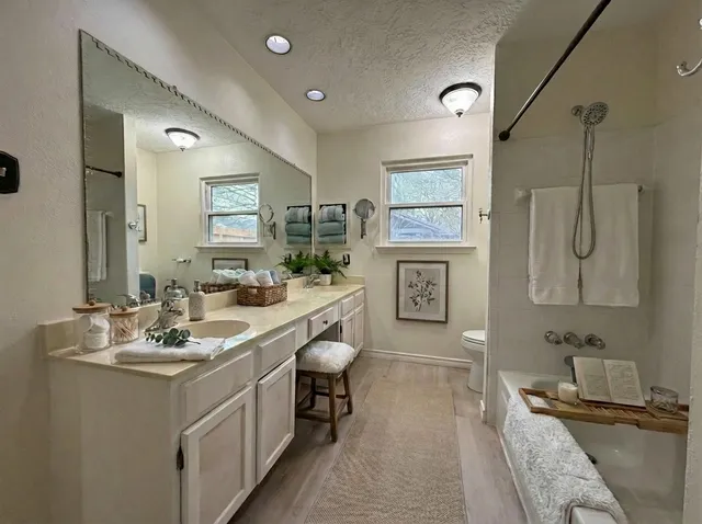 a spacious bathroom with a double vanity sink a mirror and a bathtub