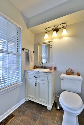a bathroom with a sink mirror vanity and toilet