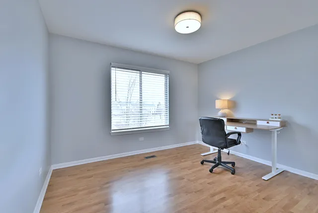 a view of a workspace with furniture and a window