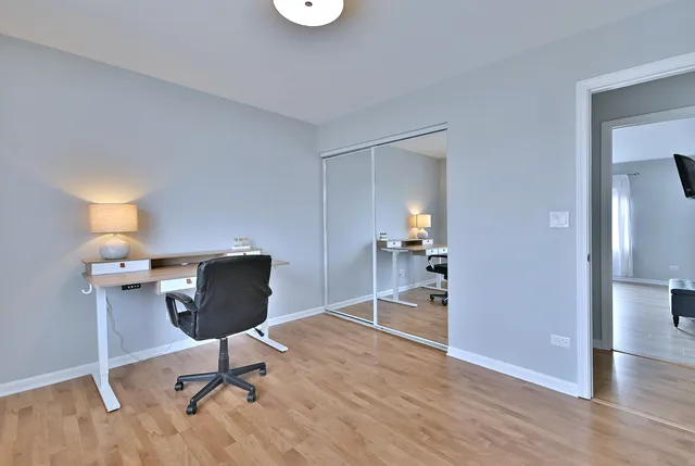 a view of a workspace with furniture and wooden floor