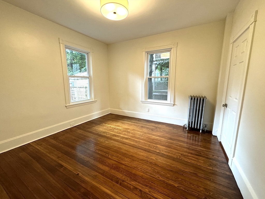 11 East Milton Road, Unit 1 Brookline, MA 02445 - Photo 11 of 24 a view of an empty room with wooden floor and a window