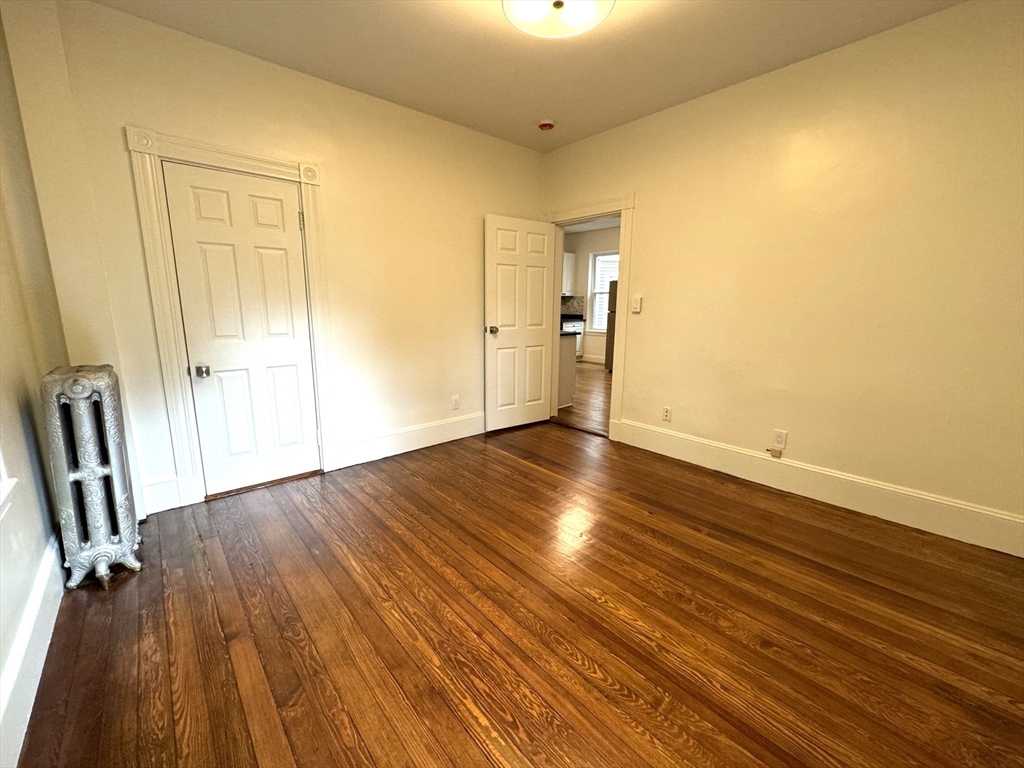 11 East Milton Road, Unit 1 Brookline, MA 02445 - Photo 13 of 24 an empty room with wooden floor and a window