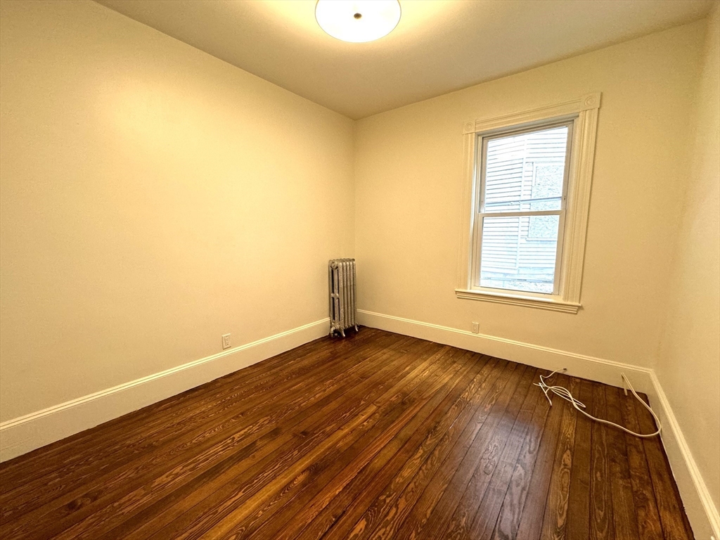 11 East Milton Road, Unit 1 Brookline, MA 02445 - Photo 14 of 24 an empty room with wooden floor and windows
