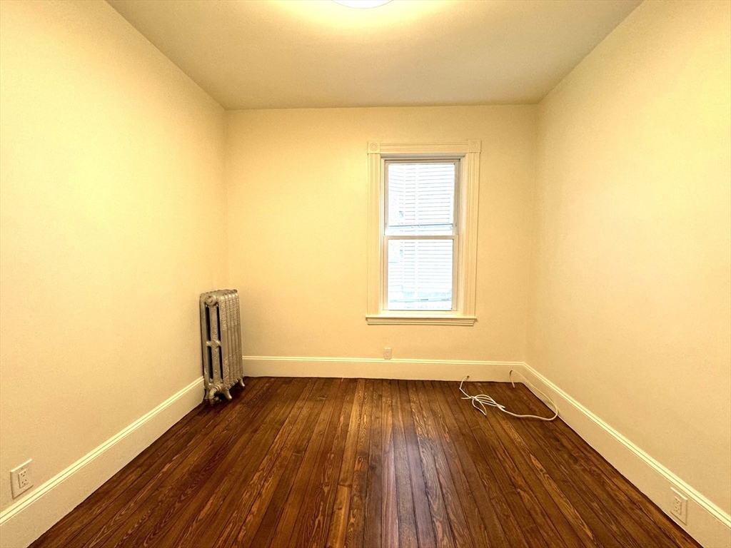 11 East Milton Road, Unit 1 Brookline, MA 02445 - Photo 15 of 24 a view of empty room with wooden floor and fan