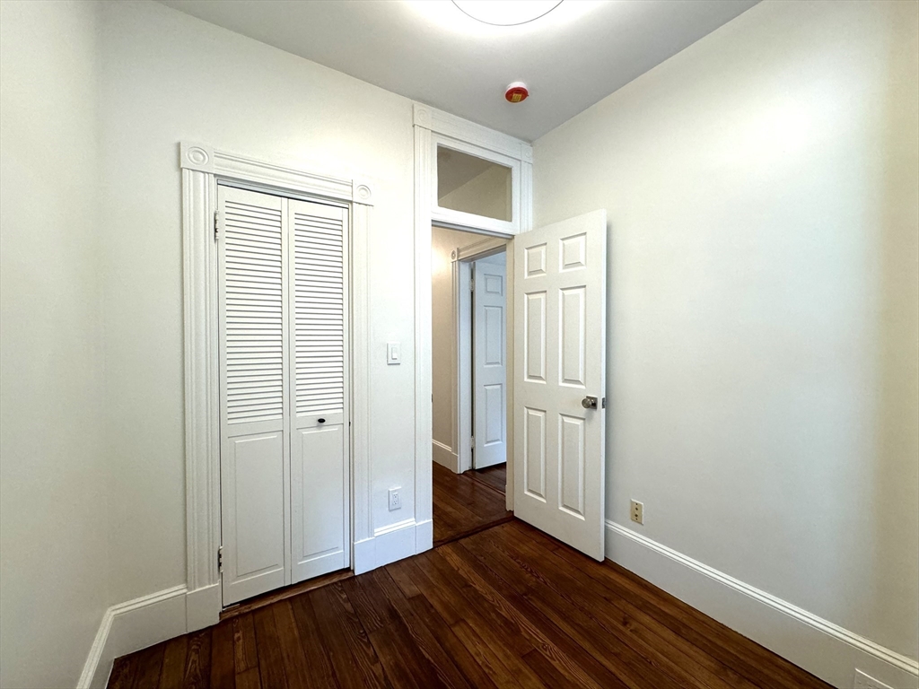 11 East Milton Road, Unit 1 Brookline, MA 02445 - Photo 17 of 24 an empty room with wooden floor and closet