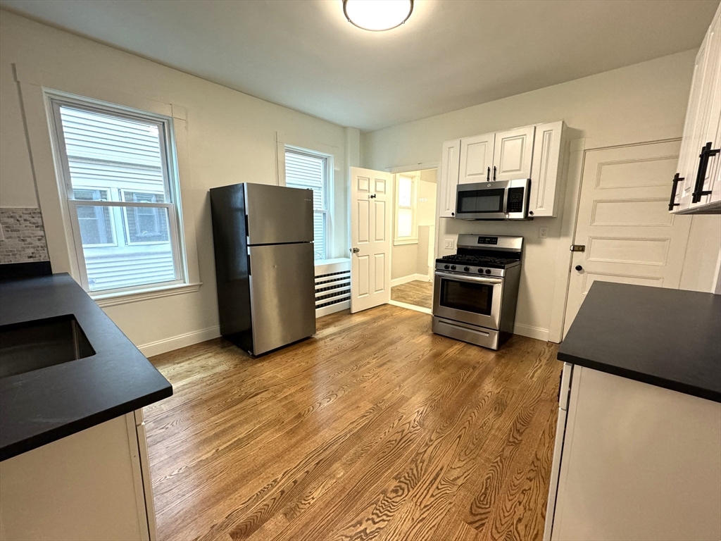 11 East Milton Road, Unit 1 Brookline, MA 02445 - Photo 2 of 24 a kitchen with stainless steel appliances a refrigerator stove and microwave