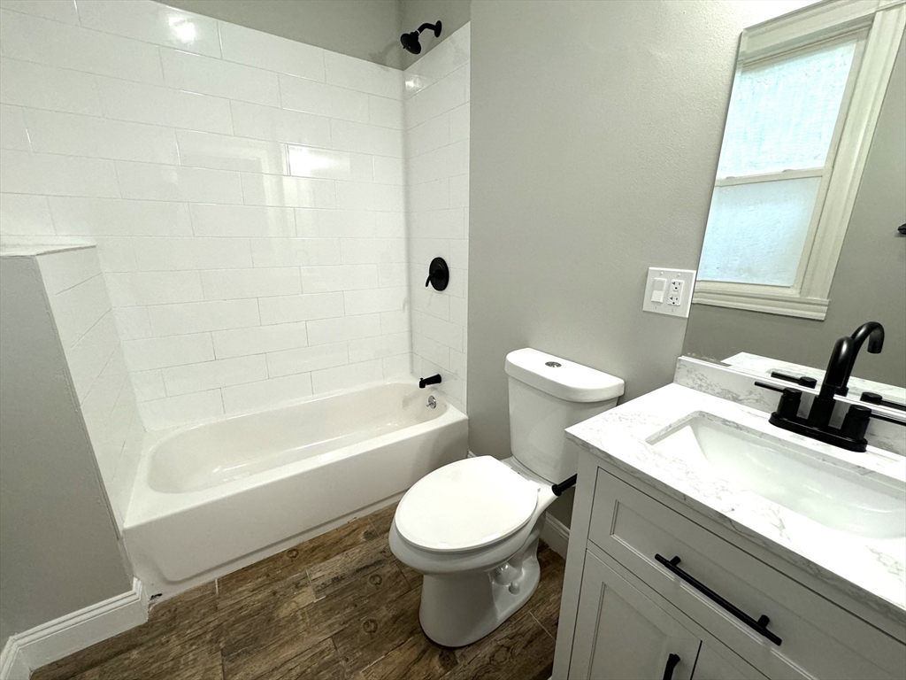 11 East Milton Road, Unit 1 Brookline, MA 02445 - Photo 21 of 24 a bathroom with a granite countertop toilet sink and mirror