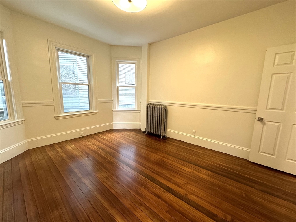 11 East Milton Road, Unit 1 Brookline, MA 02445 - Photo 10 of 24 an empty room with wooden floor and windows