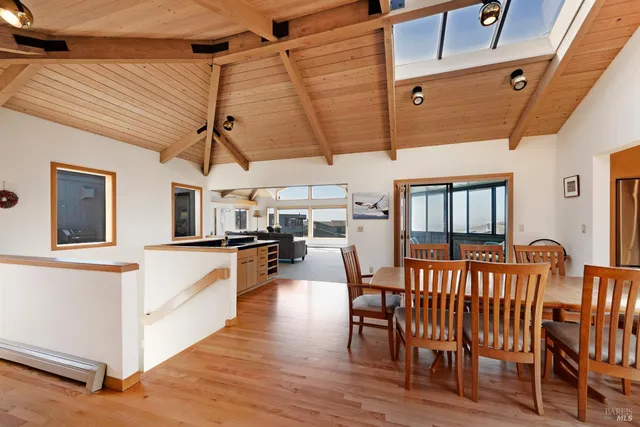 a kitchen with stainless steel appliances a stove top oven a sink a refrigerator white cabinets and wooden floor