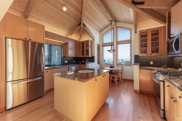 a kitchen with stainless steel appliances granite countertop a stove and wooden floors