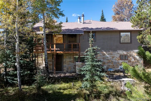 a front view of a house with yard garage and trees