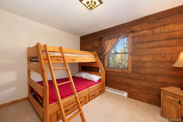 a living room with couches a coffee table a flat screen tv and two couches