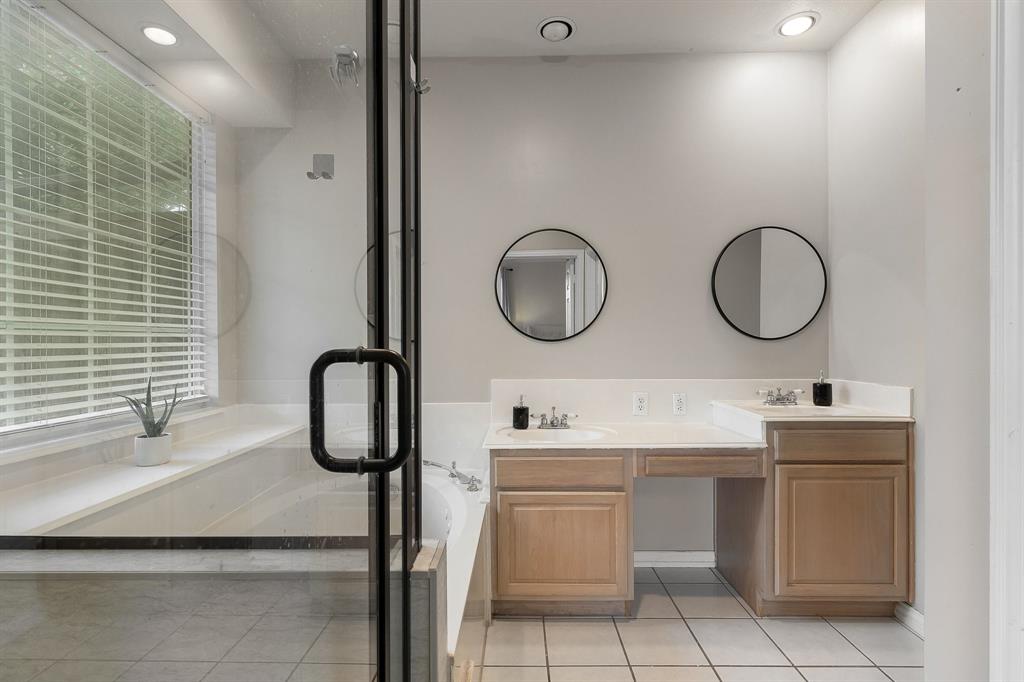 18240 Midway Road, Unit 1301 Dallas, TX 75287 - Photo 15 of 25 Bathroom featuring a glass-enclosed shower, built-in soaking tub, dual vanities with integrated sinks, wood cabinetry, and tiled flooring