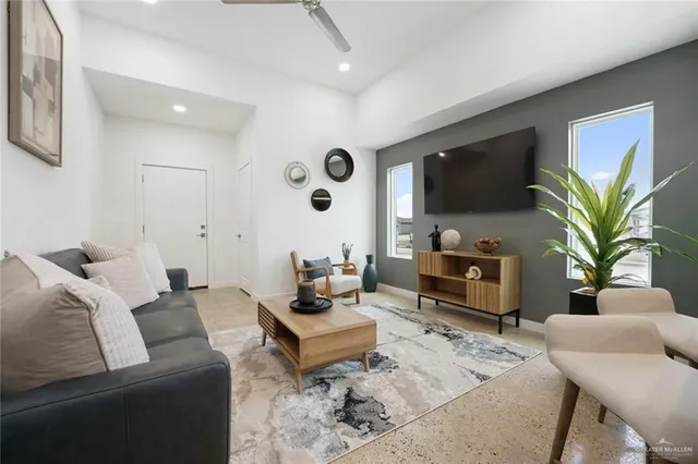 a living room with furniture a wooden floor and a potted plant