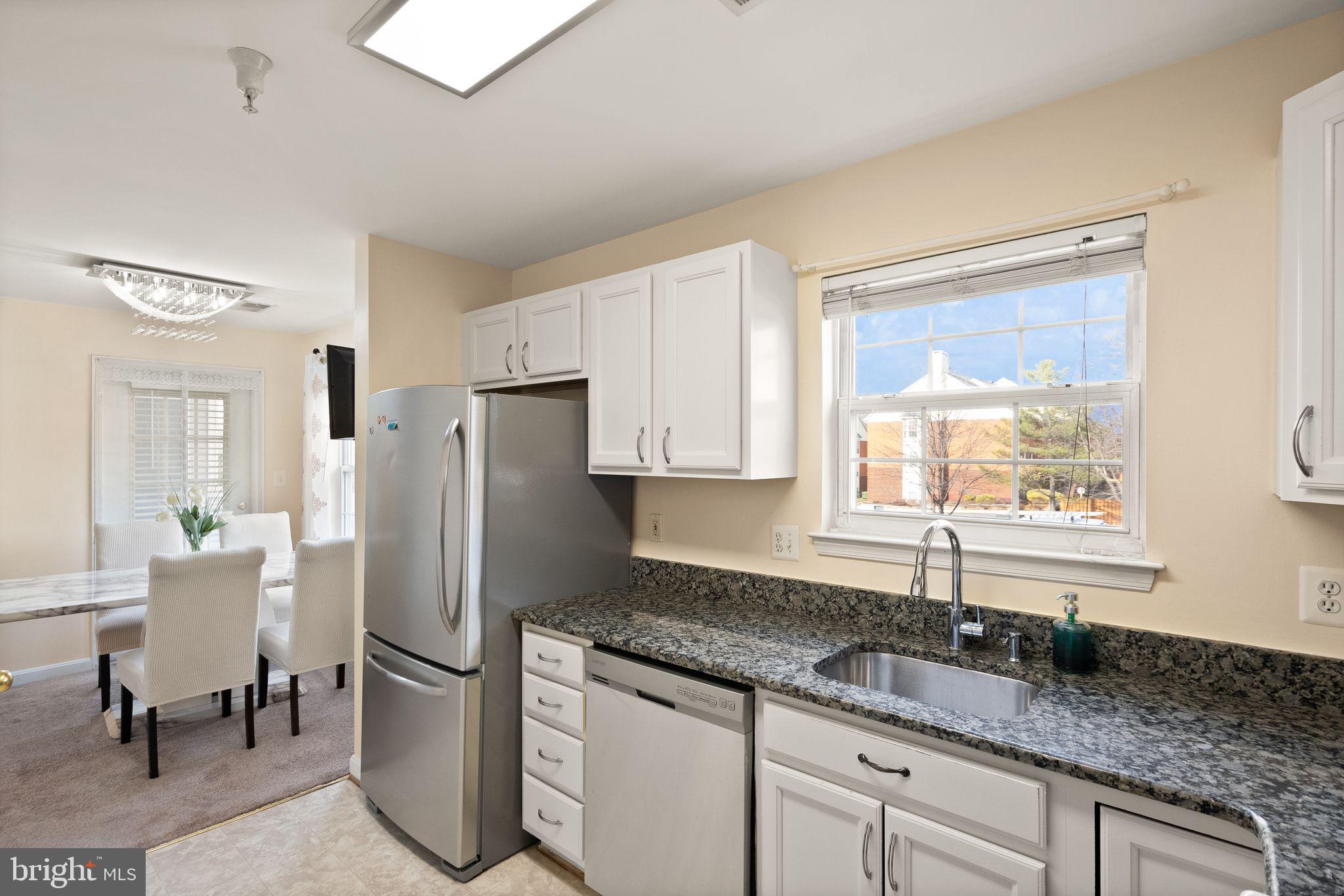 521 Constellation Square Southeast, Unit E Leesburg, VA 20175 - Photo 12 of 27 a kitchen with granite countertop a refrigerator and a sink