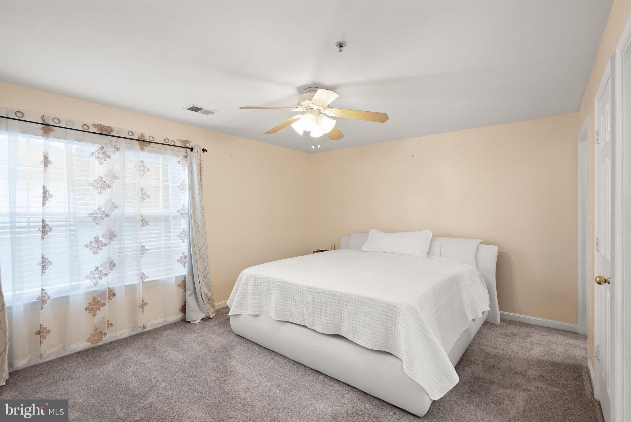 521 Constellation Square Southeast, Unit E Leesburg, VA 20175 - Photo 13 of 27 a bedroom with a bed and a chandelier
