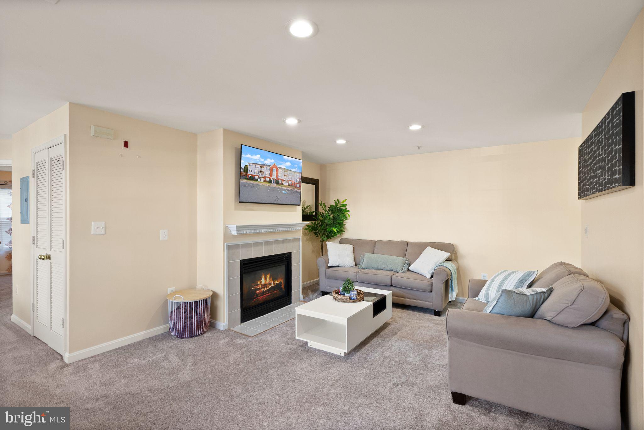 521 Constellation Square Southeast, Unit E Leesburg, VA 20175 - Photo 3 of 27 a living room with furniture and a fireplace