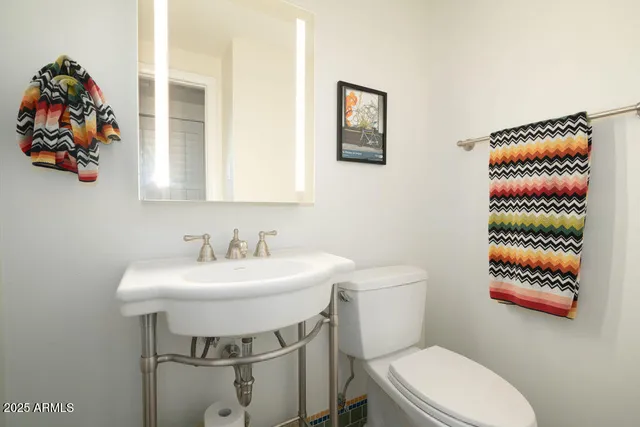 a bathroom with a toilet a sink and a mirror