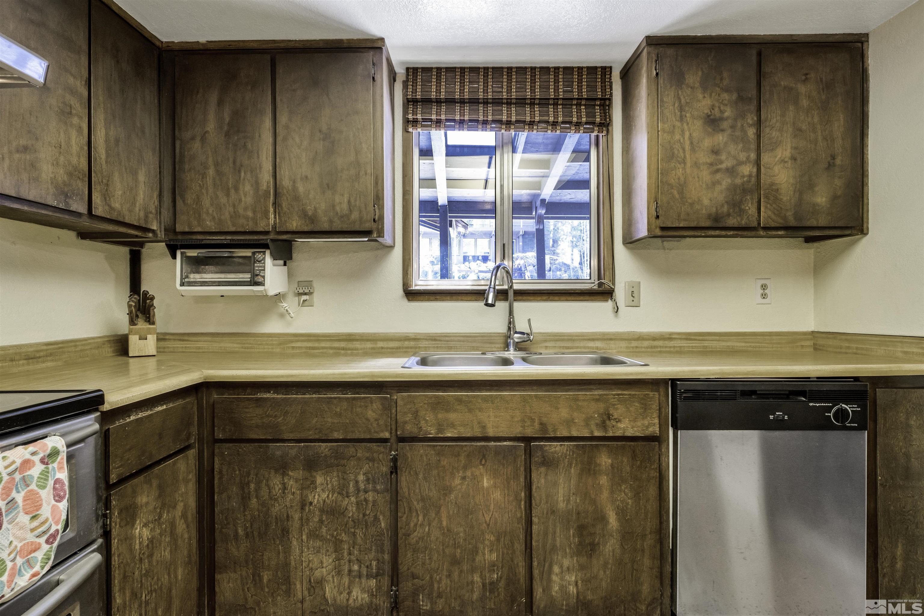 174 Juniper Drive Stateline, NV 89449 - Photo 14 of 32 a kitchen with stainless steel appliances granite countertop a sink and a microwave