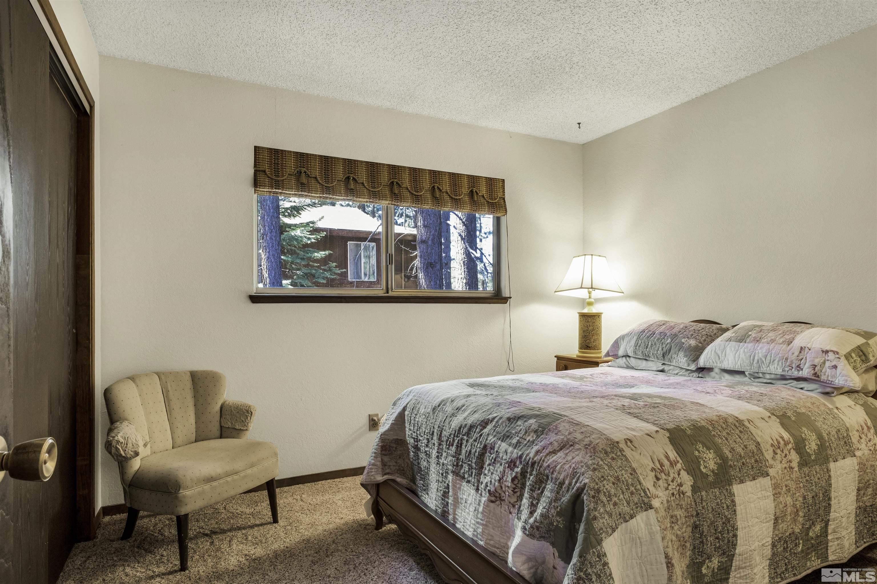 174 Juniper Drive Stateline, NV 89449 - Photo 18 of 32 a bedroom with a bed and a couch