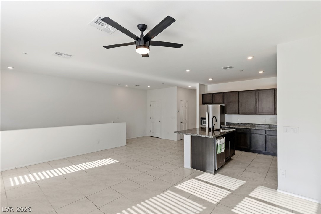 6227 Runestone Street Las Vegas, NV 89113 - Photo 19 of 33 This open concept space features a kitchen island and sleek stainless steel appliances.