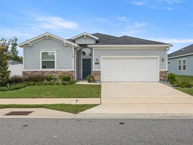 a view of a house with a yard and large tree